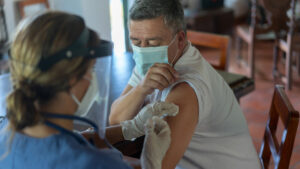 Adult Latin American man getting a COVID-19 vaccine at his rural house.