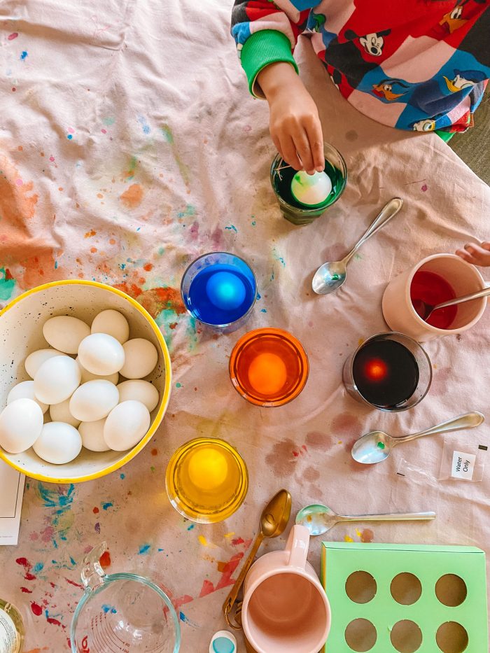 A child paints eggs.